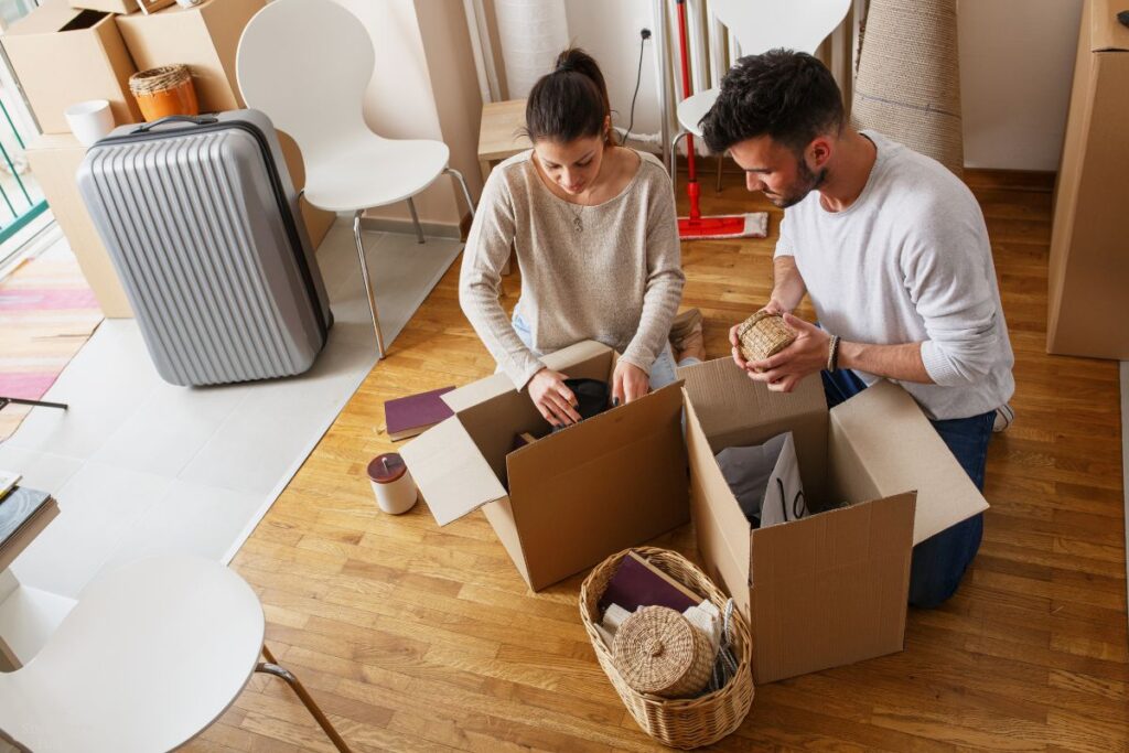 man and woman putting items into boxes