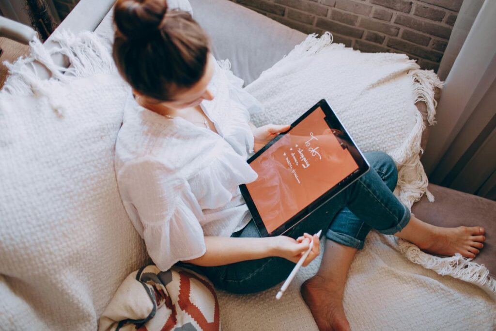 woman writing to do list on tablet