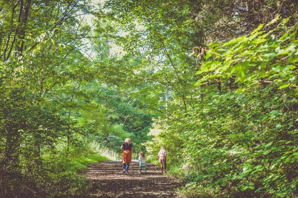 mom walking with kids down a dirt path