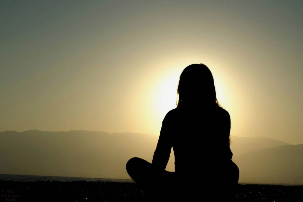 person sitting cross legged at sunrise